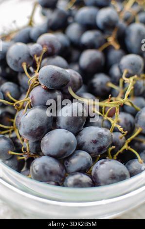 Uva scura appena raccolta in uno shot da primo piano di ciotola pronto da mangiare Foto Stock
