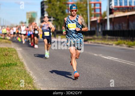 Gruppo di corridori maschi che gareggiano in una gara su strada in una giornata di sole Foto Stock