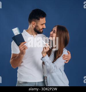 In piedi e sorridendo. Le coppie sono pronte a viaggiare, con i biglietti. Foto Stock