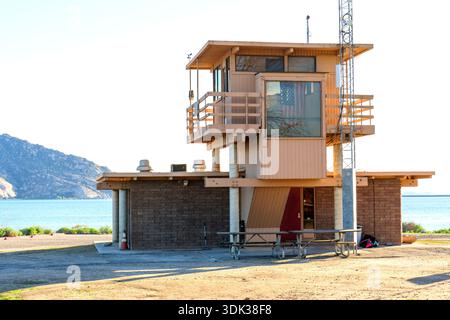 Parris, California - 8 dicembre 2025: La torre di osservazione della Lake Perris State Recreation area si affaccia sulle acque turchesi e sulle montagne in una giornata luminosa, Foto Stock