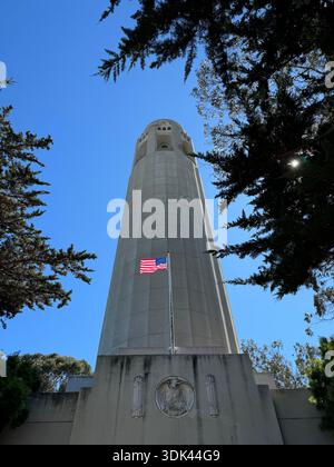 Coit Tower vista dal basso con bandiera americana a San Francisco, California, USA. Foto Stock