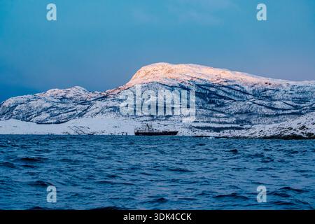 Norvegia, contea di Troms, Skjervøy, Kvænangen, paesaggio, montagne innevate, alba, nave da spedizione Foto Stock