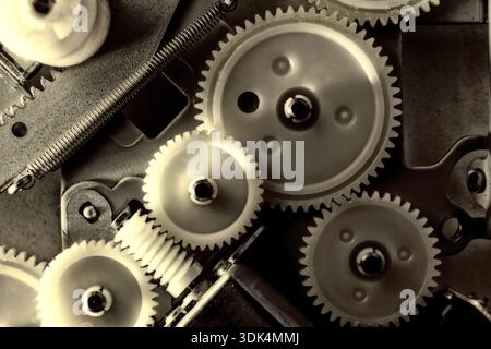 Primo piano di ingranaggi meccanici con interblocco in macchinari industriali, che mostrano ingegneria di precisione, automazione e tecnologia di produzione. Nero A. Foto Stock