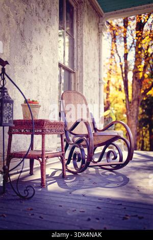 Old Country House's Veranda con sedia a dondolo in una luce soffusa d'autunno, Hunterdon County, New Jersey, Stati Uniti Foto Stock
