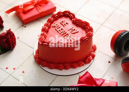 Dolce torta bento con scatole regalo e rose rosse su sfondo piastrellato bianco. Festa di San Valentino Foto Stock