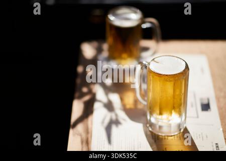 Due bicchieri di birra al sole sul tavolo Foto Stock