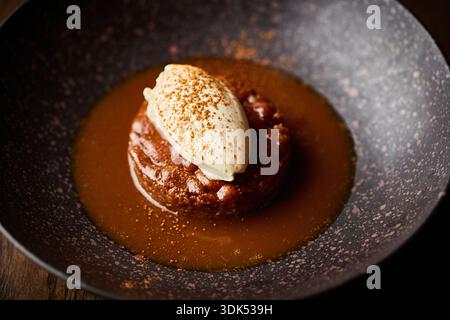 Budino di toffee appiccicoso con salsa al caramello e gelato alla vaniglia Foto Stock