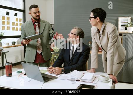Team multietnico di business che discute della strategia di progetto nell'ufficio moderno Foto Stock