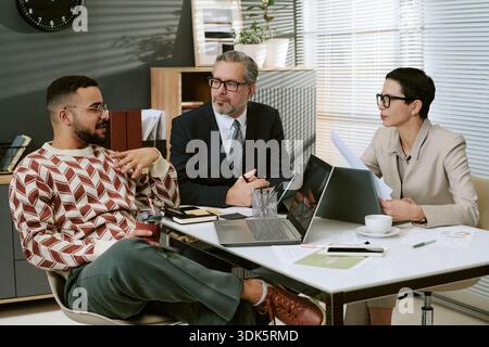 Team multietnico di business che discute della strategia di progetto durante la riunione dell'ufficio Foto Stock