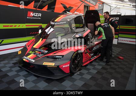 Vista frontale di tre quarti di una KTM X-Bow GT2 nera e rossa con cabina di pilotaggio aperta e vano motore esposto, in fase di configurazione nel paddock del team Foto Stock