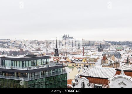 il panorama del castello di praga mostra la prima neve che copre i tetti storici Foto Stock