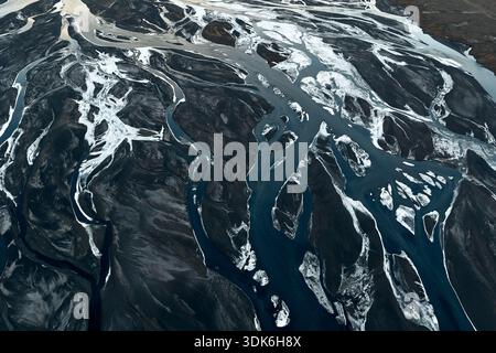 Canali del fiume glaciale intrecciati che creano schemi astratti terrestri Foto Stock