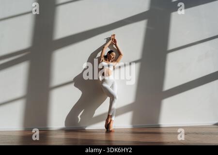 Appoggiato al muro. Bella giovane donna con il corpo sottile è al chiuso. Foto Stock