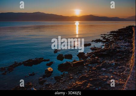 Tramonto sull'Adriatico sulla costa rocciosa Foto Stock