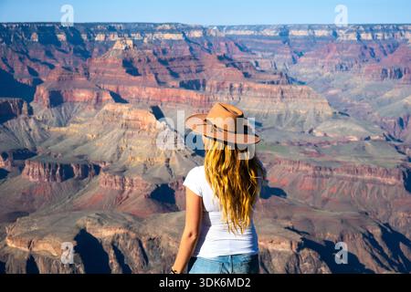 Giovane donna con cappello da sole che gode di vedute maestose del Grand Canyon vista Foto Stock