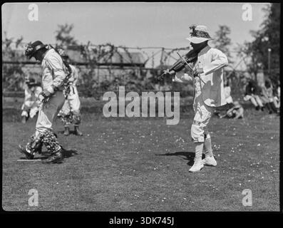 Membro della troupe Bampton Morris che si esibisce in una "Pipe Dance", accompagnato dal violinista, Bampton, West Oxfordshire, Oxfordshire, 1920-1930. Il fotografo ha scritto "Pipe Dance" e "Wells" sul negativo. Questo è un riferimento a William Nathan Wells (1868-1953) noto come 'Jingy' o 'Jinky' Wells, il violinista dei Bampton Morris. Foto Stock