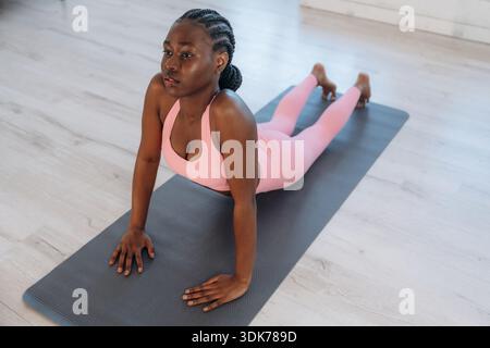 Esercizio della colonna vertebrale. La donna fa yoga a casa. Foto Stock