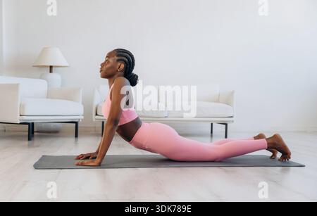 Esercizio della colonna vertebrale. La donna fa yoga a casa. Foto Stock