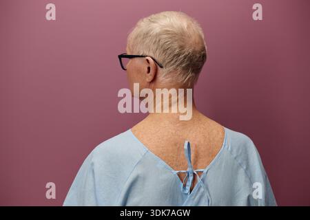 Uomo anziano che indossa abito medico in piedi nel centro vascolare Foto Stock
