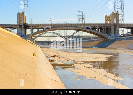 Los Angeles, California - 10 gennaio 2026: Sesta strada viadotto architettura storica sul fiume Los Angeles vista dal pavimento in cemento del canale con po Foto Stock