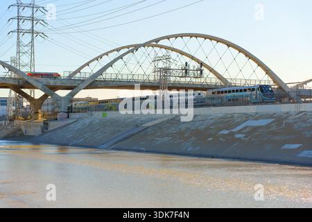 Los Angeles, California - 10 gennaio 2026: Moderna architettura del Sixth Street Bridge con iconici archi in cemento sopra un treno pendolare e urbano Foto Stock