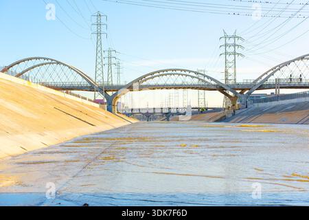 Los Angeles, California - 10 gennaio 2026: Archi del viadotto della sesta strada che si estendono sul canale del fiume Los Angeles in cemento con energia elettrica tra Foto Stock