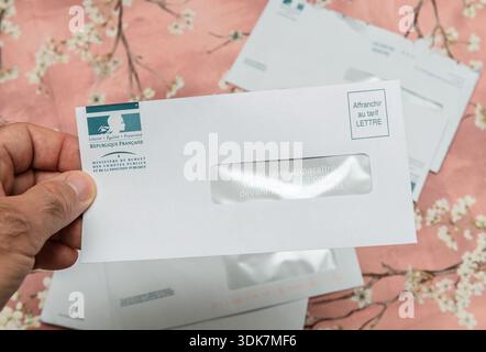 Parigi, Francia - 12 agosto 2025: Primo piano di una busta di lettere del governo francese tenuta a mano che mostra la posta ufficiale della pubblica amministrazione su fl Foto Stock
