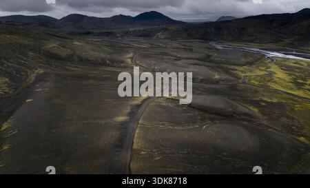 Vista aerea di una strada tortuosa che attraversa aspre altopiani vulcanici sotto un cielo spiovente, rivelando la bellezza selvaggia dell'Islanda, Selfoss, Islanda. Foto Stock