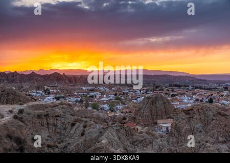 Tramonto aereo sulla città del Canyon del deserto con gruppi di case e strade tortuose, Guadix, Spagna Foto Stock