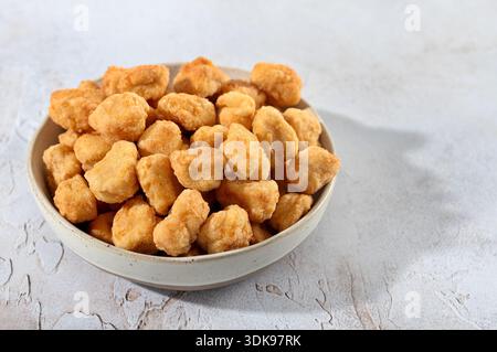 Ciotola di popcorn croccanti di pollo su sfondo bianco. Menu fast food, spuntini. Foto Stock