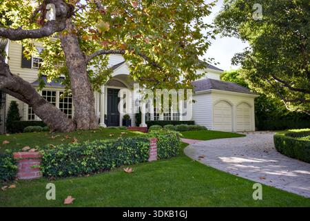 Elegante casa di periferia con vialetto e lussureggiante giardino verde Foto Stock