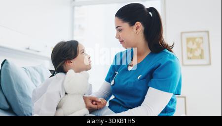 Donna, infermiera e letto d'ospedale con bambino per il controllo sanitario o la consultazione in clinica. Donna, medico o pediatra che tiene per mano il bambino o. Foto Stock