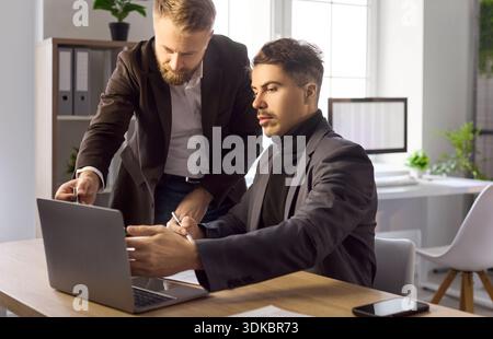 Colleghi aziendali che collaborano con un laptop per la pianificazione e l'analisi dei progetti Foto Stock