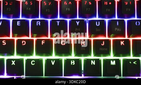 Tastiera da gioco rgb brillante con luce al neon colorata. Questa moderna tecnologia informatica ha un arcobaleno di colore per la digitazione, creando futuristici e dinamici Foto Stock