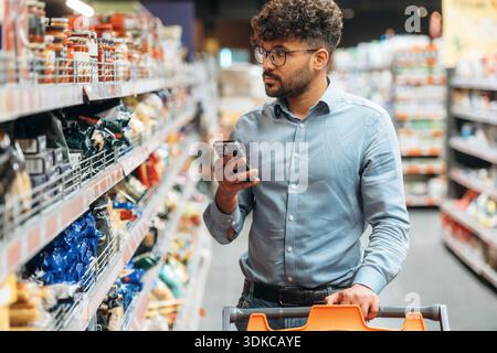 Vista frontale. L'uomo è al negozio di alimentari. Foto Stock