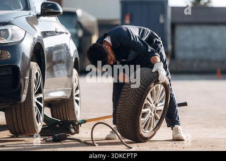 Il meccanico è con l'auto all'aperto. Foto Stock