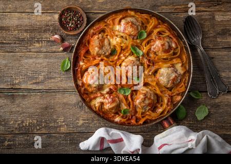 polpette in nidi di pasta con salsa di pomodoro, vista dall'alto, sfondo in legno Foto Stock
