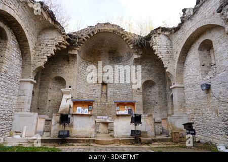 Vecchia chiesa di San Nicola vicino al lago Mavrovo, Macedonia del Nord, parzialmente sommersa in passato, circondata da alberi autunnali, con esterno e interno vi Foto Stock