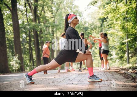 Prepararsi per la maratona facendo esercizi caldi. Un gruppo di corridori si trova all'aperto. Foto Stock
