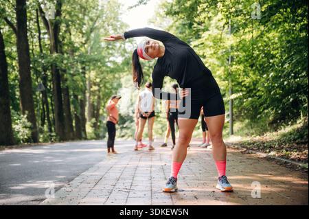 Prepararsi per la maratona facendo esercizi caldi. Un gruppo di corridori si trova all'aperto. Foto Stock