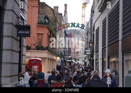 Iconico cartello arcobaleno di Carnaby Street sopra l'affollato viale pedonale con cabina telefonica rossa a Londra Soho. Londra, Inghilterra Foto Stock