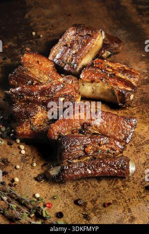 Cibo, costolette di maiale fritte marinate con spezie, aglio e cumino. Scatto verticale Foto Stock