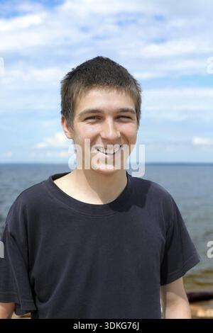Felice ritratto di un giovane uomo sul mare Foto Stock