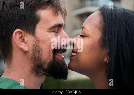 Coppia interrazziale che condivide un tenero momento di affetto Foto Stock