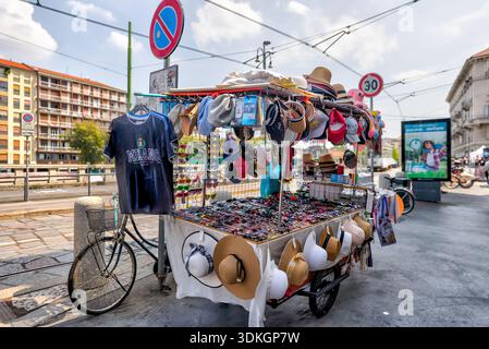 Venditori ambulanti che vendono cappelli e souvenir nel quartiere dei Navigli di Milano, Lombardia, Italia. Foto Stock