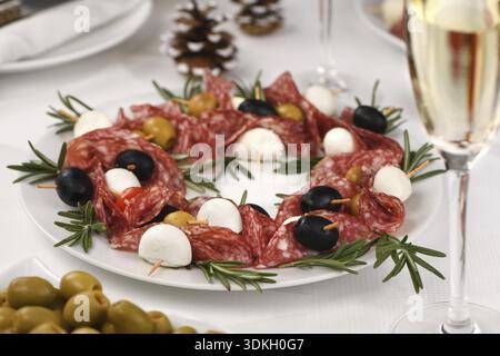 Cibo, corona di Natale - antipasto. Tartine di salame con olive, mozzarella baby Foto Stock