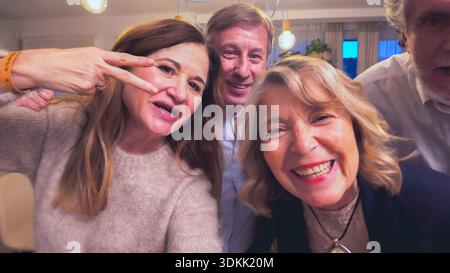 Amici anziani che fanno selfie grimace insieme a casa Foto Stock