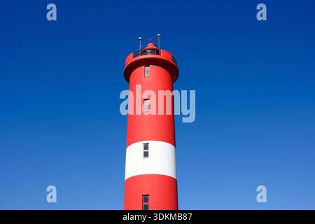 Faro rosso e bianco contro il cielo blu. Foto Stock