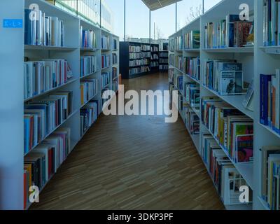 Caen, Francia 1 febbraio 2026. Interno di una moderna biblioteca con file di scaffali, libri organizzati e pavimento in legno. Concetto di istruzione, conoscenza Foto Stock