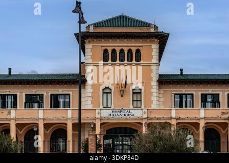 La facciata storica dell'ospedale Malva-Rosa di Valencia presenta piastrelle tradizionali, gallerie ad arco e dettagli architettonici mediterranei. Foto Stock